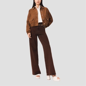 Model wearing Maje brown cropped suede-effect jacket with dark brown wide-leg trousers, white shirt and white slide sandals.