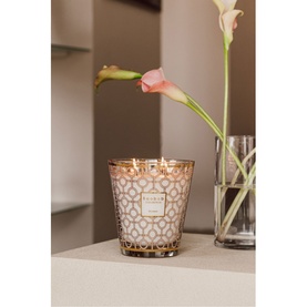 Baobab Women Signature Scented Candle 1kg in gold-toned geometric glass vessel, lit wick, styled on shelf beside pink florals