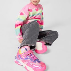 Model wearing Billy Blush denim grey jeans, styled with a pink striped heart-print jumper and pink chunky trainers