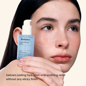 Model with Biodance serum held to cheek, blue pump bottle with hydration and soothing relief claim visible on packaging