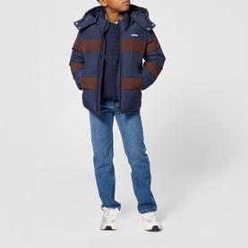 Model wearing Boss Kids navy puffer jacket with brown contrast stripes and hood, styled with blue jeans and white trainers