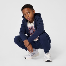 Model wearing Boss Kids Navy Sweat Bottoms, styled with matching navy zip-up hoodie and white graphic tee, with white trainers.