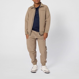 Model wearing Boss Kids Navy T-shirt, styled with matching beige zip jacket and jogger trousers, white trainers