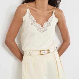 Model with Dehanche Hollyhock Leather Belt in ivory, gold and silver-tone rounded buckle, smooth finish, styled with cream lace-trim camisole.