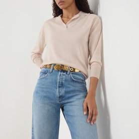 Model with Dehanche Rivet Suede Belt in ochre and gold, worn over a light pink top and blue jeans, gold-tone buckle and rivet detailing visible.