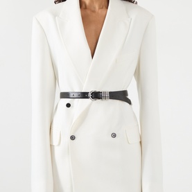 Model with Dehanche Hollyhock Leather Belt in black with silver-tone buckle, styled over a white double-breasted blazer dress.