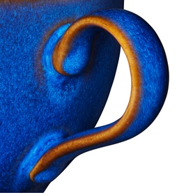 Denby Cup in blue stoneware, close-up of curved handle with warm terracotta clay edge detail visible beneath glaze