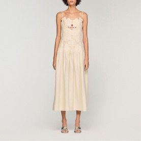 Model wearing Sandro Womens French Dress in clear, midi-length with floral embroidery bodice and full skirt, styled with silver strappy heels