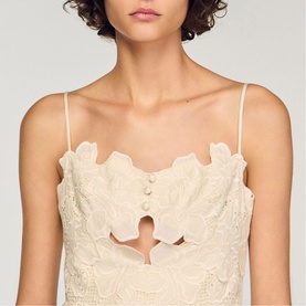 Model wearing Sandro Womens French Dress in clear, featuring lace fabric, scalloped neckline, button detail and cut-out waist