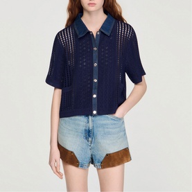 Model wearing Sandro navy blue open-knit short sleeve shirt with collar, styled with light wash denim and suede shorts.