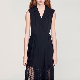 Model wearing Sandro Womens French Dress in black, featuring sleeveless blazer-style bodice, pleated skirt with sheer lace hem panel.