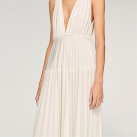Model wearing Sandro Womens French Dress in clear, featuring deep V-neckline, pleated skirt, and cinched waist detail