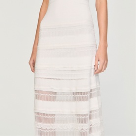 Model wearing Sandro Womens French Dress in clear white, featuring tiered lace and mesh stripe detailing, midi length