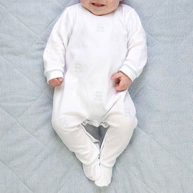 Model wearing Emile Et Rose pale blue all-in-one sleepsuit with subtle printed details and footed legs