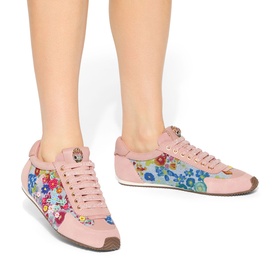 Model wearing Kurt Geiger London blue floral print low-top lace-up trainers with pink upper, multicolour flower detailing and tan sole.