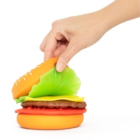 Keycraft The Big Squij squishy burger toy in red, with hand lifting the bun top to reveal layered food pieces underneath