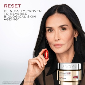 Model with Lanc&ocirc;me Absolue Longevity Reset Cream, holding a red capsule, with cream jar visible alongside