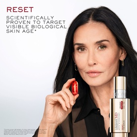 Model with Lanc&ocirc;me Absolue Longevity Reset Serum, holding a red capsule, with serum bottle visible beside her