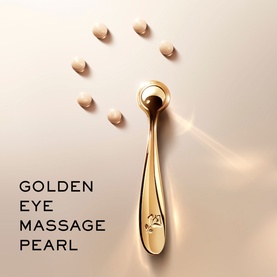 Lanc&ocirc;me Golden Eye Massage Pearl gold-tone facial massage tool with pearl-shaped roller tip, shown with scattered pearls on neutral background