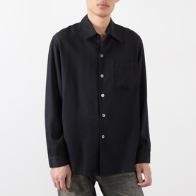 Model wearing Our Legacy casual shirt in Draping Black Lyocell, relaxed fit with chest pocket, long sleeves, styled with dark trousers.