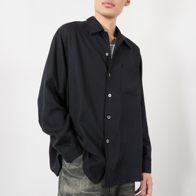 Model wearing Our Legacy casual shirt in Draping Black Lyocell, oversized fit with chest pocket, paired with grey jeans.