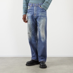 Model wearing Our Legacy Azure Print jeans in a relaxed straight fit with heavy faded wash detail, styled with black chunky-sole shoes.