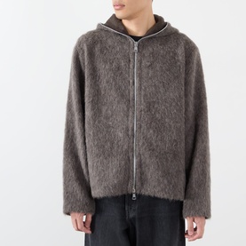 Model wearing Our Legacy Mole Grey Hairy Wool Zip Through hoodie with textured fluffy finish, styled with dark trousers.