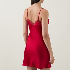 Model wearing Simone Perele Love Me Lace Chemise in Opera Red, showing low V-back, lace trim detailing, thin adjustable straps and mini length.