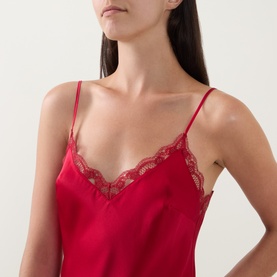 Model wearing Simone Perele Love Me Lace Chemise in Opera Red, showing V-neckline with scalloped lace trim and thin adjustable straps