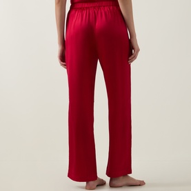 Model wearing Simone Perele PJ Pants in Opera Red, 100% silk with elasticated waistband, wide-leg silhouette, back view