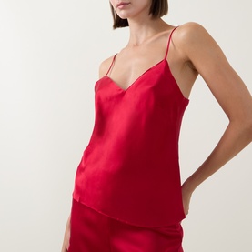 Model wearing Simone Perele Opera Red silk camisole top with V-neckline and thin straps, styled with matching red shorts