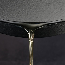 Tramontina pan with gold-toned handle detail, close-up of black textured exterior and sleek curved rim