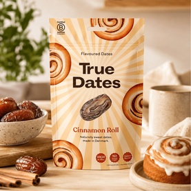True Dates Cinnamon Roll Flavoured Dates pouch, styled with dates in a bowl and a cinnamon roll on a wooden board