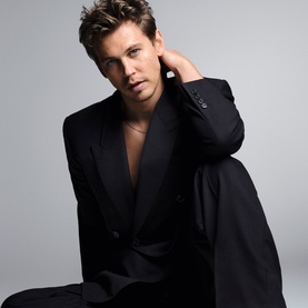 Model wearing black open-chest blazer suit, gold chain necklace, styled for YSL Myslf Intense Eau de Toilette men's fragrance campaign