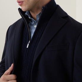 Model wearing Zegna navy blue wool cashmere coat, styled with a quilted zip gilet and light blue shirt underneath.