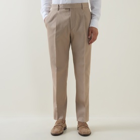 Model wearing Zegna Formal Slim-Leg Trousers in light taupe, mid-rise with front pleats and pressed creases, styled with suede loafers.