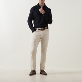 Model wearing Zegna navy cotton polo shirt, styled with cream trousers, brown leather belt and dark brown loafers