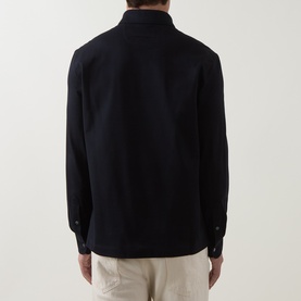 Model wearing Zegna navy cotton polo shirt, rear view, styled with light-coloured trousers