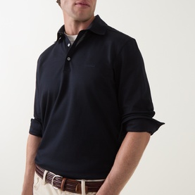 Model wearing Zegna navy cotton polo shirt with three-button placket, styled with beige trousers and a brown belt.
