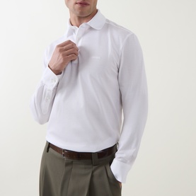 Model wearing Zegna white long-sleeve cotton polo shirt, styled with olive trousers and brown belt.
