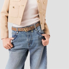 Model wearing Maje brown belt with gold eyelet detail, styled with light blue wide-leg jeans and camel blazer