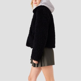 Model wearing Maje red textured fleece cropped jacket with grey hood, styled with khaki mini skirt, side view