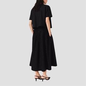 Model wearing Maje Womens French Dress in red, shown from behind, styled with black strappy heeled sandals.