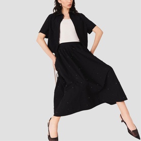 Model wearing Maje Womens French Dress in red, styled with a black cropped jacket and black heels