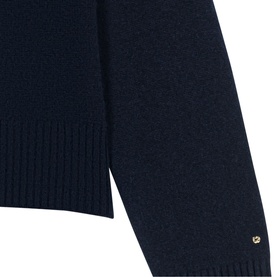 Maje navy knit sweater close-up showing ribbed cuff and gold logo embellishment at hem