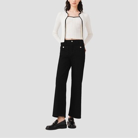 Model wearing Maje metallic-trimmed white crop top and black wide-leg trousers, styled with black loafers