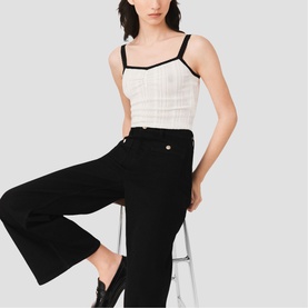 Model wearing Maje metallic camisole top with black contrast trim, styled with wide-leg black trousers and loafers