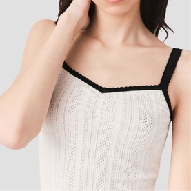 Model wearing Maje metallic knit camisole top with black lace trim straps and V-neckline, close-up detail view