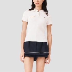 Model wearing Maje metallic short-sleeve polo top with chest pockets, styled with a navy pleated mini skirt