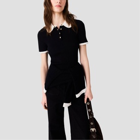 Model wearing Maje red knit polo dress with white contrast collar and cuffs, styled with wide-leg trousers and brown bag